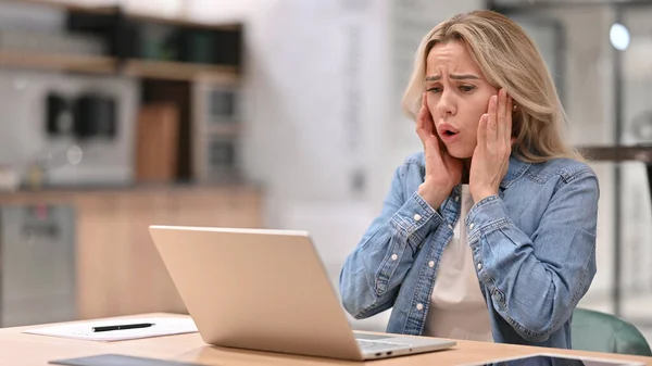 Młoda kobieta reaguje na utratę na laptopie w pracy — Zdjęcie stockowe