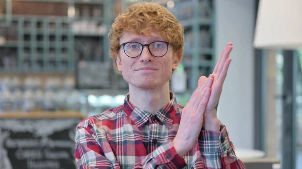 Dizüstü bilgisayarlı, alkışlayan, alkışlayan kızıl saçlı genç adamın portresi — Stok fotoğraf