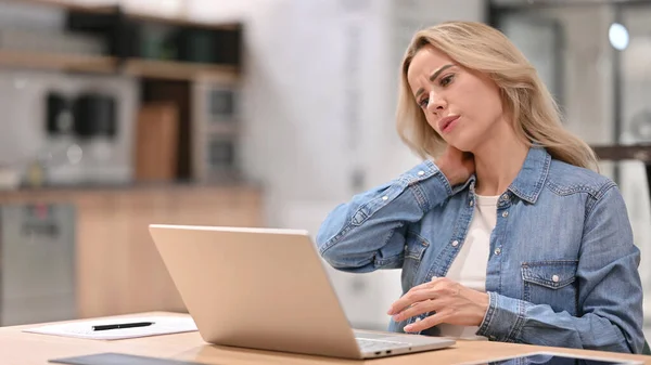 Jeune femme occasionnelle avec douleur au cou en utilisant un ordinateur portable au travail — Photo