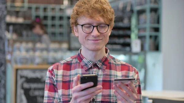 Retrato de éxito de compras en línea en Smartphone por Redhead Young Man —  Fotos de Stock