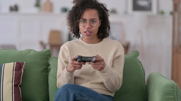 Ung afrikansk kvinna spelar TV-spel hemma — Stockfoto