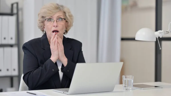 Choqué vieille femme d'affaires avec ordinateur portable regardant la caméra — Photo