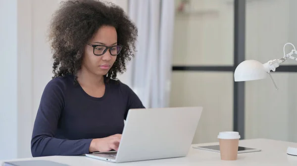 アフリカ人女性がオフィスのノートパソコンで働く — ストック写真