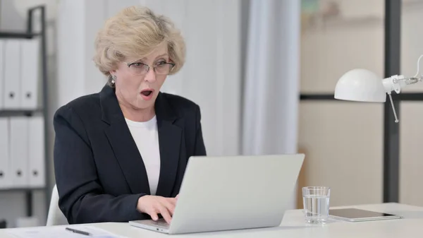 Vieille femme d'affaires se sentant choqué tout en travaillant sur ordinateur portable — Photo
