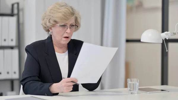 Old Businesswoman Disappointed by Loss on Documents
