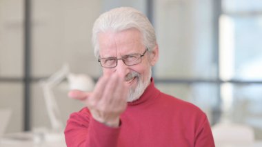 Yaşlı adam kamerayı işaret ediyor, davet ediyor 