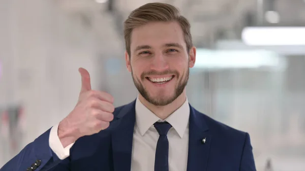 Joven empresario mostrando pulgares hacia arriba signo — Foto de Stock