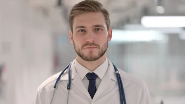 Junger männlicher Arzt blickt in die Kamera — Stockfoto