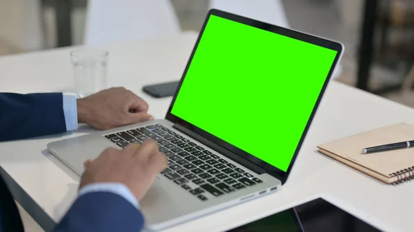 Empresario africano usando el ordenador portátil con la pantalla dominante verde del croma —  Fotos de Stock