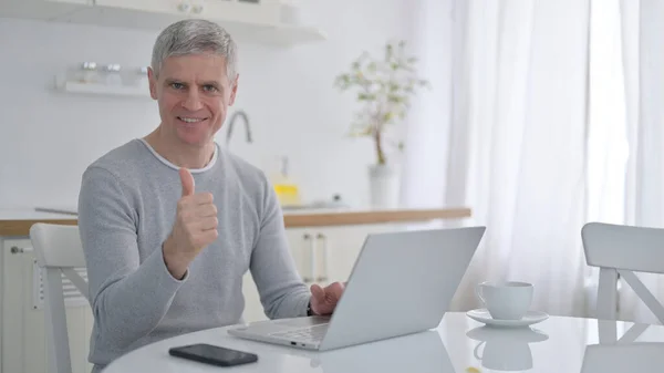 Positiver alter Mann mit Laptop macht Daumen hoch — Stockfoto