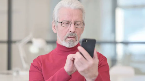 Alter Mann surft mit Smartphone im Internet — Stockfoto