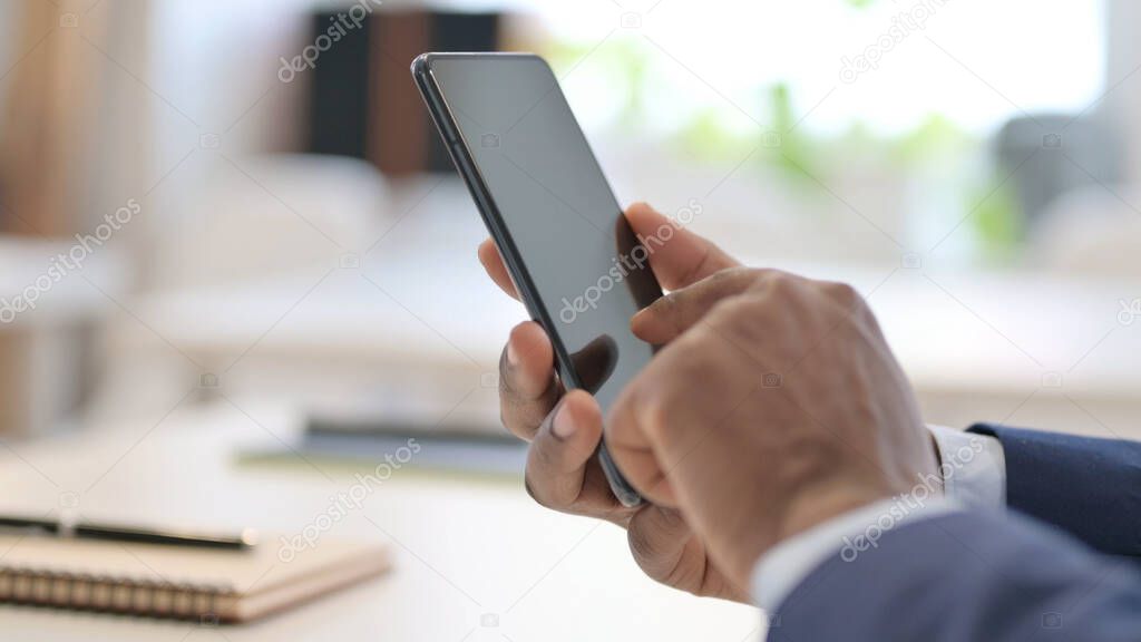 Close up of Hands of African Businessman using Smartphone
