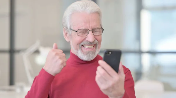 Portret van een oude man viert feest op smartphone — Stockfoto