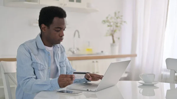 Udane zakupy online na laptopie przez African Man w domu — Zdjęcie stockowe