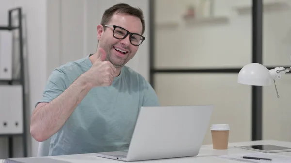 Thumbs Up by Young Man with Laptop at Work — ストック写真