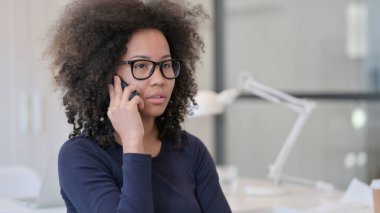 Afrikalı kadın telefonda konuşuyor.