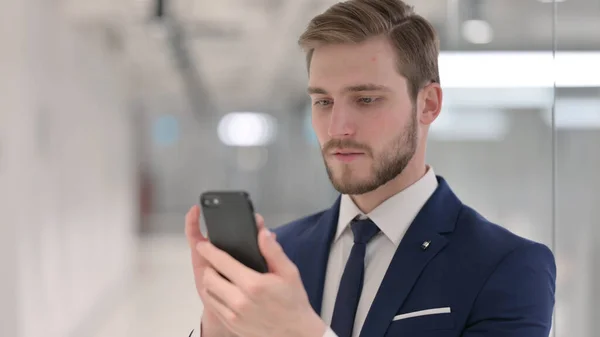 Mladý podnikatel používající smartphone, textové zprávy — Stock fotografie