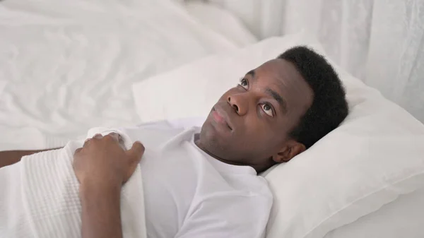 Αφρικανός ξαπλωμένος στο κρεβάτι στο σπίτι — Φωτογραφία Αρχείου