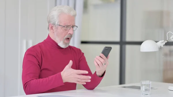 Vieil homme réagissant à la perte sur Smartphone — Photo