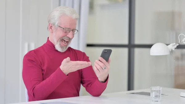 Vieil homme célèbre le succès sur Smartphone au travail — Photo