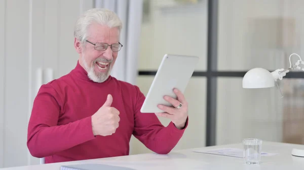 Erfolgreicher alter Mann feiert am Arbeitsplatz mit Tablet — Stockfoto