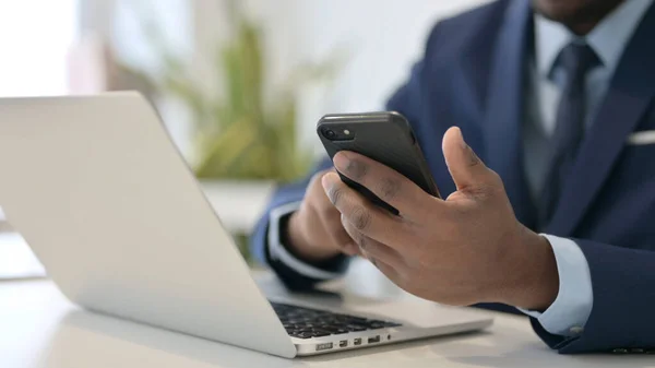 Uomo d'affari africano con computer portatile utilizzando Smartphone, Close up — Foto Stock