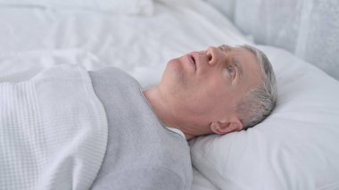 Yaşlı adam yatakta uyuyor ve kâbus görüyor.