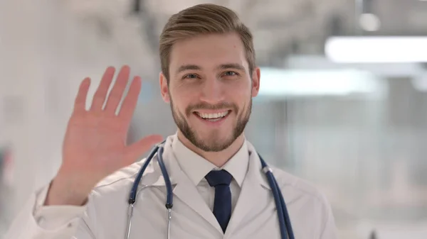 Joven macho doctor hablando en videollamada — Foto de Stock