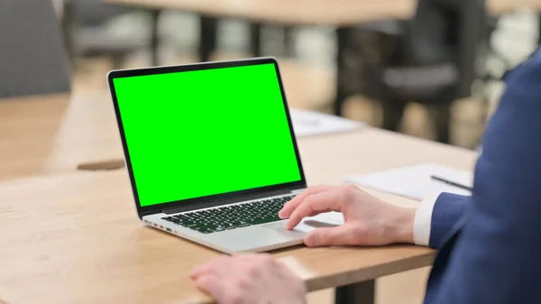 Бизнесмен, работающий над ноутбуком с Green Mock Up Screen — стоковое фото