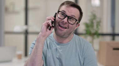 Genç adam telefonda konuşuyor, pazarlık yapıyor.