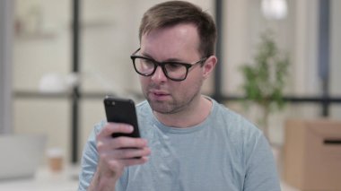 Genç adam smartphone üzerinde Internet tarama