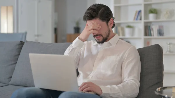 Müder junger Mann mit Kopfschmerzen bei der Arbeit am Laptop — Stockfoto