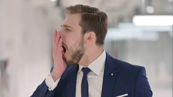 Tired Young Businessman Yawning at Work — Stock Photo, Image