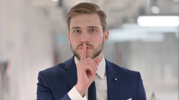 Ung affärsman visar tyst tecken, Finger på läppar — Stockfoto