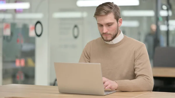 Giovane uomo che lavora sul computer portatile in ufficio — Foto Stock