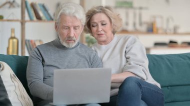 Evde Dizüstü bilgisayar kullanan yaşlı çift