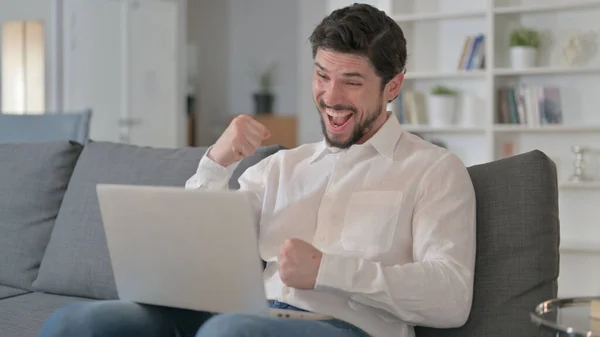 Uomo ambizioso che celebra il successo sul computer portatile a casa — Foto Stock