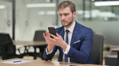 İş yerinde Smartphone kullanan İşadamı 