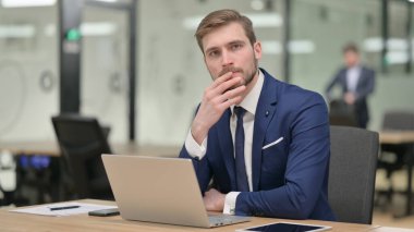 İş adamı ofisteki kameraya bakıyor