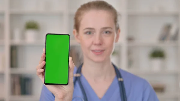 Γυναίκα γιατρός κρατώντας Smartphone με πράσινη οθόνη — Φωτογραφία Αρχείου