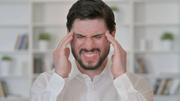 Müder junger Mann mit Kopfschmerzen — Stockfoto