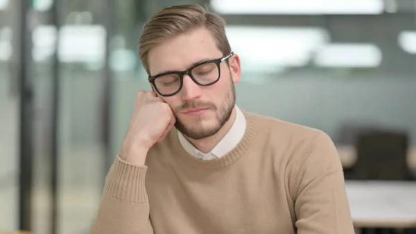 Jeune homme faisant la sieste au bureau — Photo