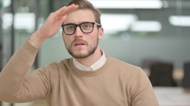 Meraklı genç adam etrafa bakıyor, arıyor. 