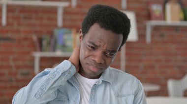 Yorgun Afrikalı adamın boynu ağrıyor.