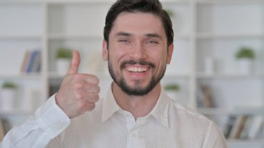 Genç adam başparmağını kaldırıyor.