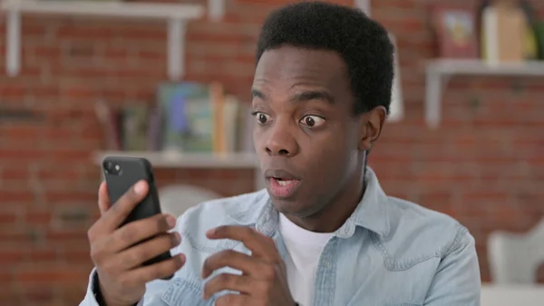 Mladý africký muž se ztrátou na Smartphone — Stock fotografie