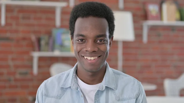 Glimlachende Afrikaanse man kijkend naar de camera — Stockfoto