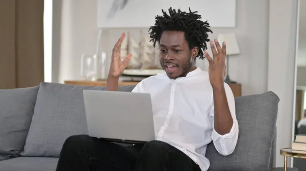 Afrikansk man firar framgång på laptop hemma — Stockfoto