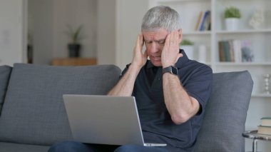 Çalışkan orta yaşlı adamın koltukta başı ağrıyor.