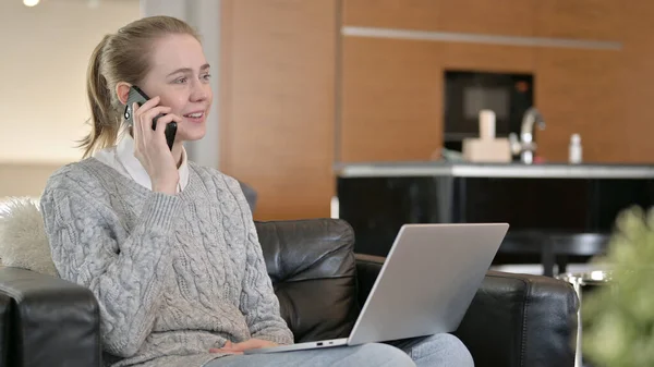 Mulher com Laptop Falando no telefone em casa — Fotografia de Stock